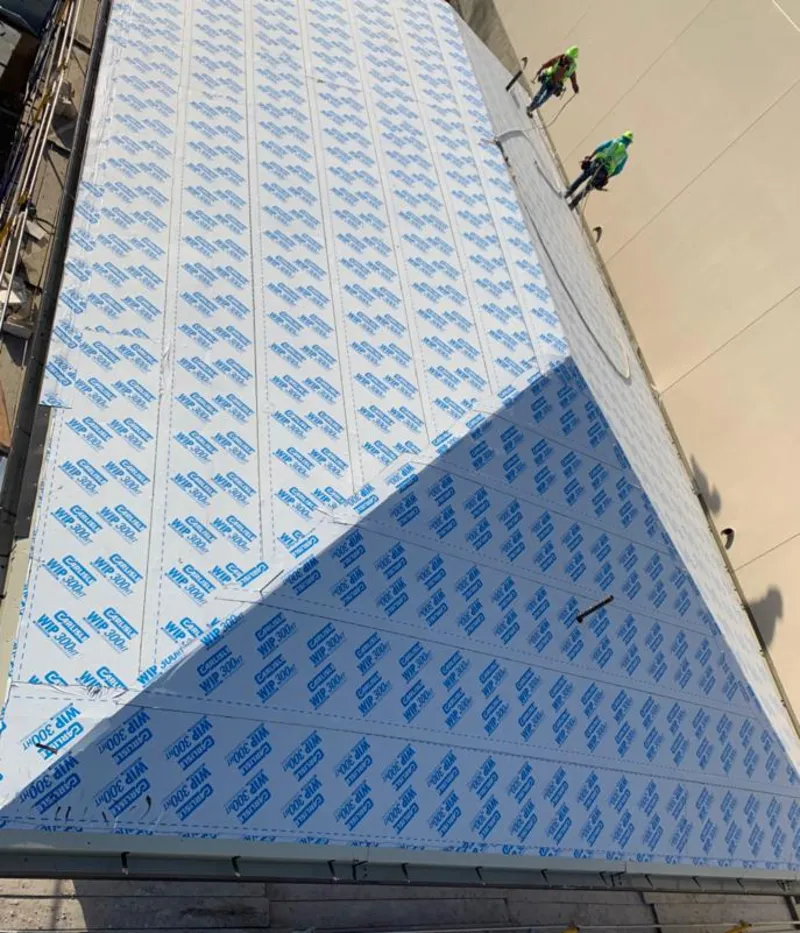 Professional roofers installing underlayment on a metal roof in East Haven